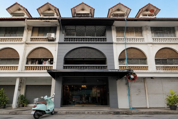 A two-story building with a cafe named 'Terminal 53 Cafe' on the ground floor. - Terminal Garage (Phuket)