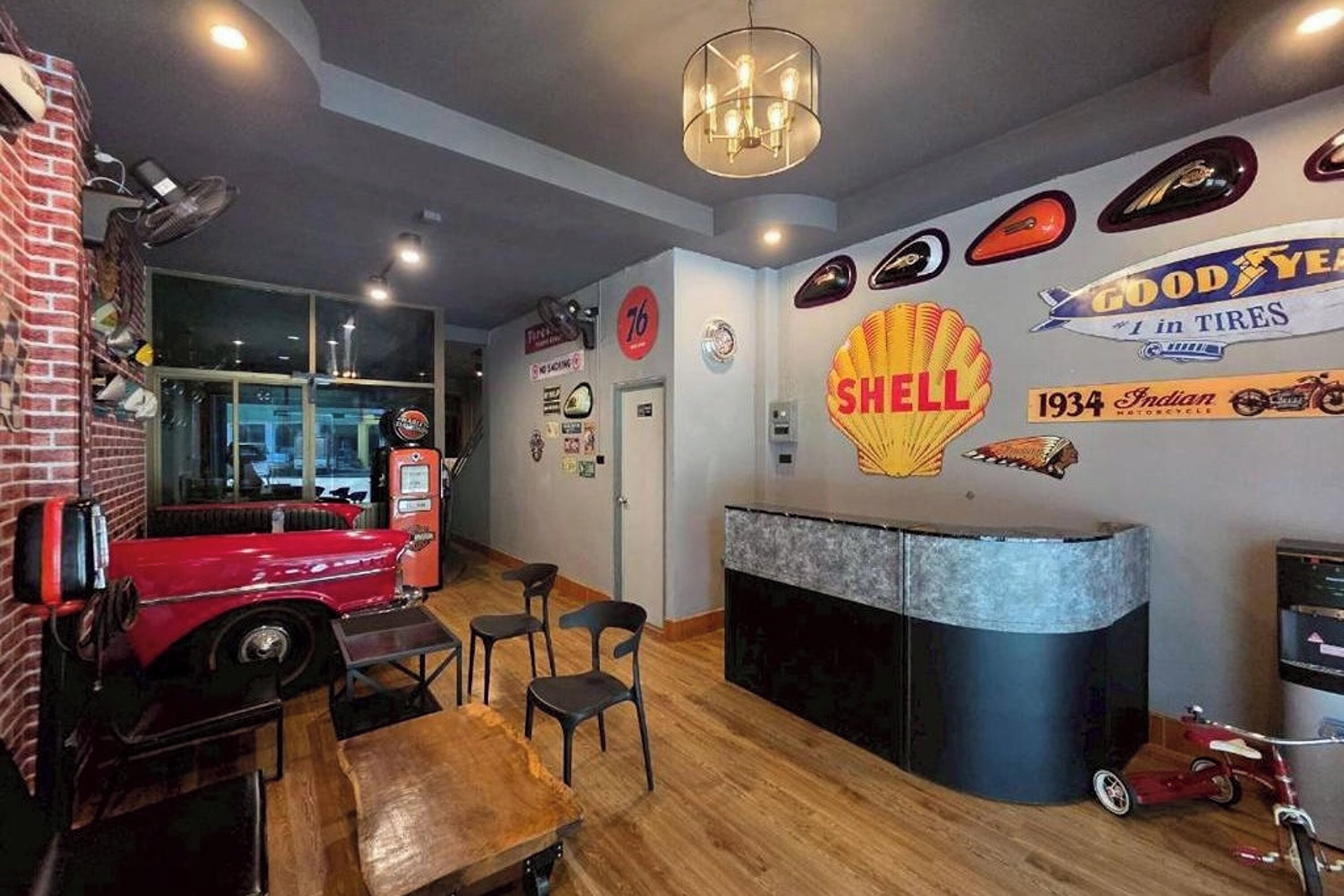 A restaurant interior with a vintage car display, a Shell logo, and a Goodyear tire advertisement.