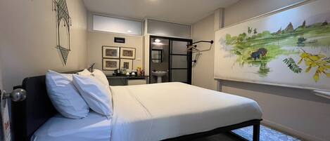 Un dormitorio con cama, escritorio y una obra de arte colgada en la pared.