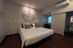Une chambre moderne avec un grand lit, une œuvre d’art accrochée au mur et un système de climatisation intégré.