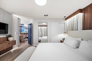Habitación de hotel con cama, televisión, escritorio y baño.