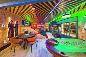 A room with a roulette table, a brick wall, a seating area, and a shop named 'Supplies'. - 8BR house sleeps 24 near Disney area (Clermont)