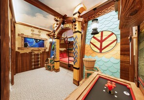 A playroom with wooden furniture, a mural, and a pool table. - 8BR house at Windsor Cay Resort (Clermont)
