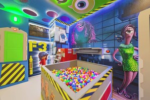 A colorful room with a ball pit, a character statue, and a large mural. - 8BR house sleeps 24 near Disney area (Clermont)