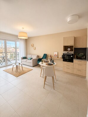 A modern apartment with a living room, dining area, and kitchen.
