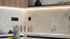 A modern kitchen with a wooden cabinet, a black vase, and a fruit bowl on the counter. - Villa Sea View, Saint George Horizon Villas (Rethymno)
