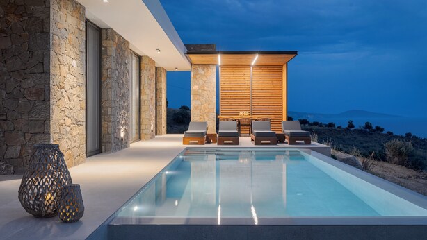 A modern poolside area with stone walls, wooden paneling, and lounge chairs. - Villa Sea View, Saint George Horizon Villas (Rethymno)