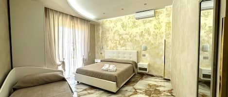 Chambre Quadruple Deluxe, vue mer | Espace de travail pour ordinateur portable, Wi-Fi gratuit