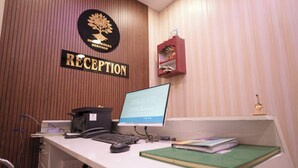 Ein Empfangsbereich mit Computer, Telefon und einem Bücherregal.