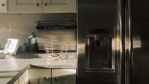 Una cocina con electrodomésticos de acero inoxidable, horno empotrado y dispensador de agua.