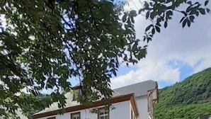 Ett belagt område avsett för fotgängare med en byggnad som har en trappa och en liten utesittplats.