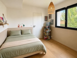 A bedroom with a bed, a window, a bookshelf, and a door. - Family Villa with private pool (Bègles)
