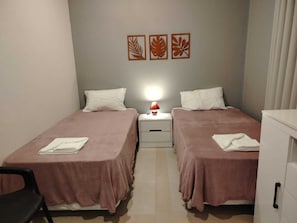 A hotel room with two beds, a nightstand with a lamp, and three wall art pieces. - 6 Guest House Spacious: Quincho Swimming Pool Games (San Bernardino)