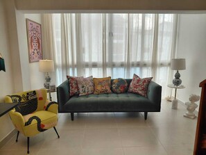 A living room with a sofa, a yellow armchair, a lamp, and a bust on a table. - 2 Bedroom Elegant Penthouse 400m from Punta Popy Beach in Las Terrenas (Las Terrenas)