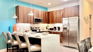 A modern kitchen with wooden cabinets, stainless steel appliances, and a granite countertop. - Private Pool, Balcony & BBQ Area Short Walk to Clubhouse (Clermont)