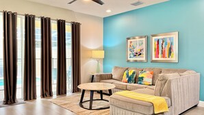 A living room with a sofa, ottoman, and a ceiling fan. - Private Pool, Balcony & BBQ Area Short Walk to Clubhouse (Clermont)