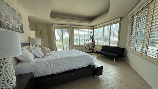 Een slaapkamer met een bed, een stoel, een bank, een lamp en een schilderij.
