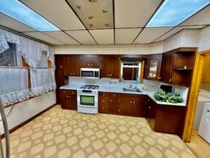 A kitchen with a stove, microwave, and sink.