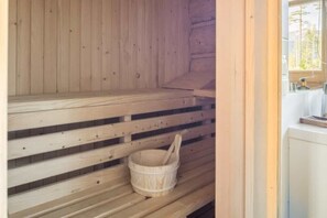 A wooden sauna with benches and a wooden bucket. - Half of a Semi-detached House With a Sauna (Koscielisko)