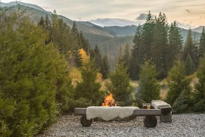 A campfire with logs, a blanket, and glasses of beer in a forest setting. - Half of a Semi-detached House With a Sauna (Koscielisko)