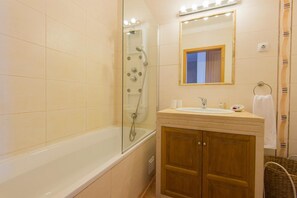 A bathroom with a bathtub, a shower, a sink, a mirror, and wooden cabinets. - Apartment 'Refugio Da Longueira' with Private Terrace, Balcony and Wi-Fi (Nascedios)