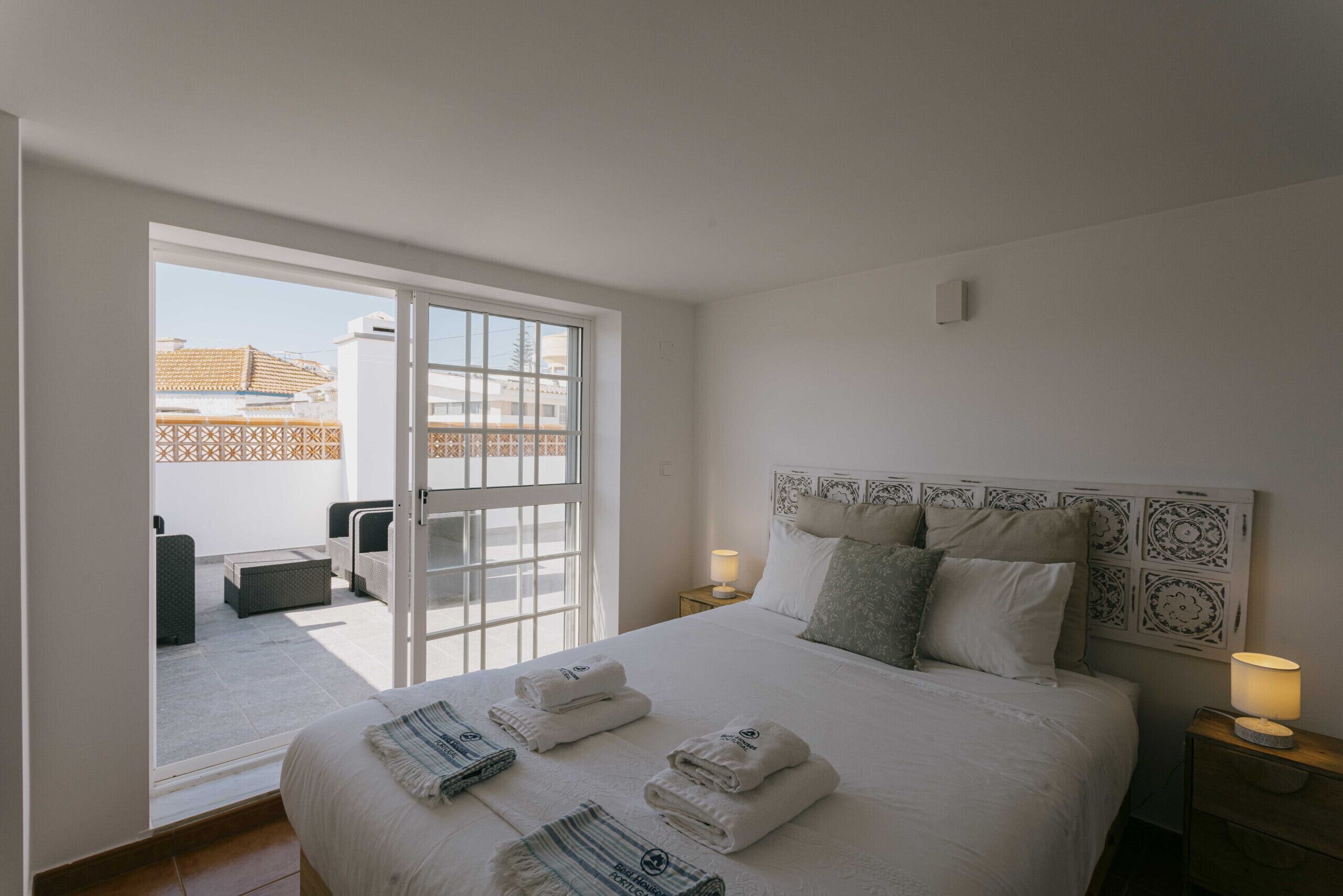 Een hotelkamer met een bed, twee nachtkastjes, een raam en uitzicht op het exterieur.