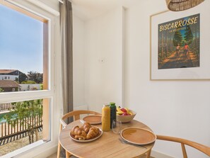 A dining table with croissants, a fruit bowl, and juice bottles. - Backside Studio for 3 - Shared Pool (Biscarrosse)
