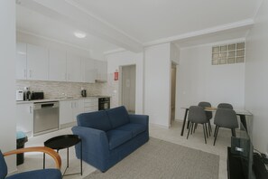 A modern living room with a blue sofa, a small table, and a TV. - Best Houses 96 - Lobo do Mar (Peniche)