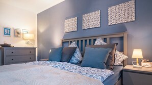 A bedroom with a bed, bedside tables, and wall decor. - Apartment "Heimathafen" with Private Terrace and Wi-Fi (Wurster Nordseeküste)