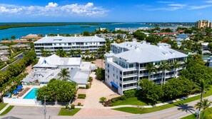 A hotel with multiple buildings, a swimming pool, and a view of the ocean. - Olde Marco Inn #403, Waterfront Island Escape (Marco Island)