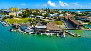 A coastal area with a dock, boats, and a building with a thatched roof. - Olde Marco Inn #403, Waterfront Island Escape (Marco Island)