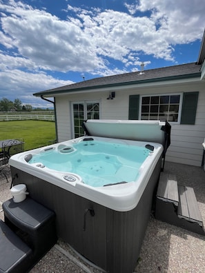 A hot tub with a control panel, a step, and a cup holder.