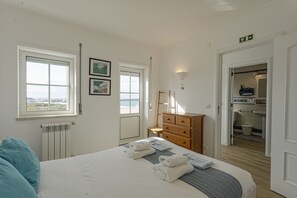 Ein Hotelzimmer mit Bett, Schminktisch, Heizkörper, Fenster und Blick nach draußen.