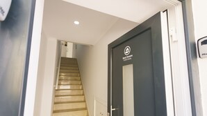 A hallway leading to a door with a sign reading 'Best Houses Portugal.'
