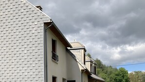 Talo, jossa on tiiliverhous, parveke ja patio, jossa on tuoleja ja aurinkovarjo.
