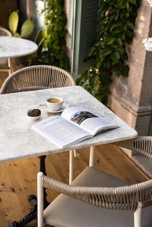 A table with a book, a cup of coffee, and a bowl of tea. - Galinis 1894 Cunda (Ayvalık)