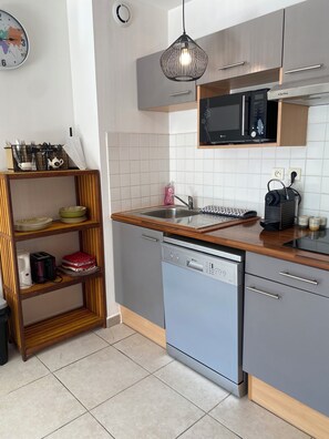 Eine moderne Küche mit Geschirrspüler, Mikrowelle und Holzböden.