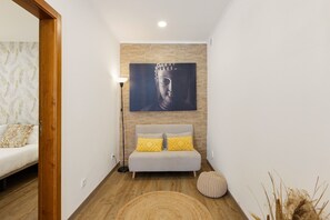 A modern room with a sofa, a floor lamp, and a Buddha painting on the wall. - Best Houses 77 - Best Village I (Peniche)