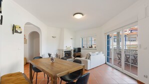 A spacious living area with a wooden dining table, black chairs, a sofa, and a TV. - Best Houses 91 - Casa D'el Rey (Amoreira)
