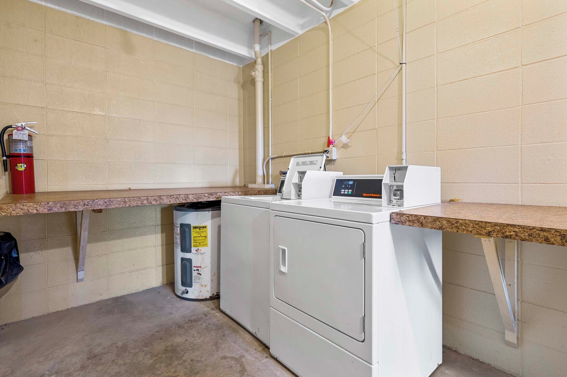 A laundry area with a washing machine, dryer, and a fire extinguisher.