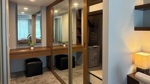 A modern room with a sliding closet, a desk with a lamp, and a small rug. - Stylish Loft Apartment Near Fishermans Village (Koh Samui)