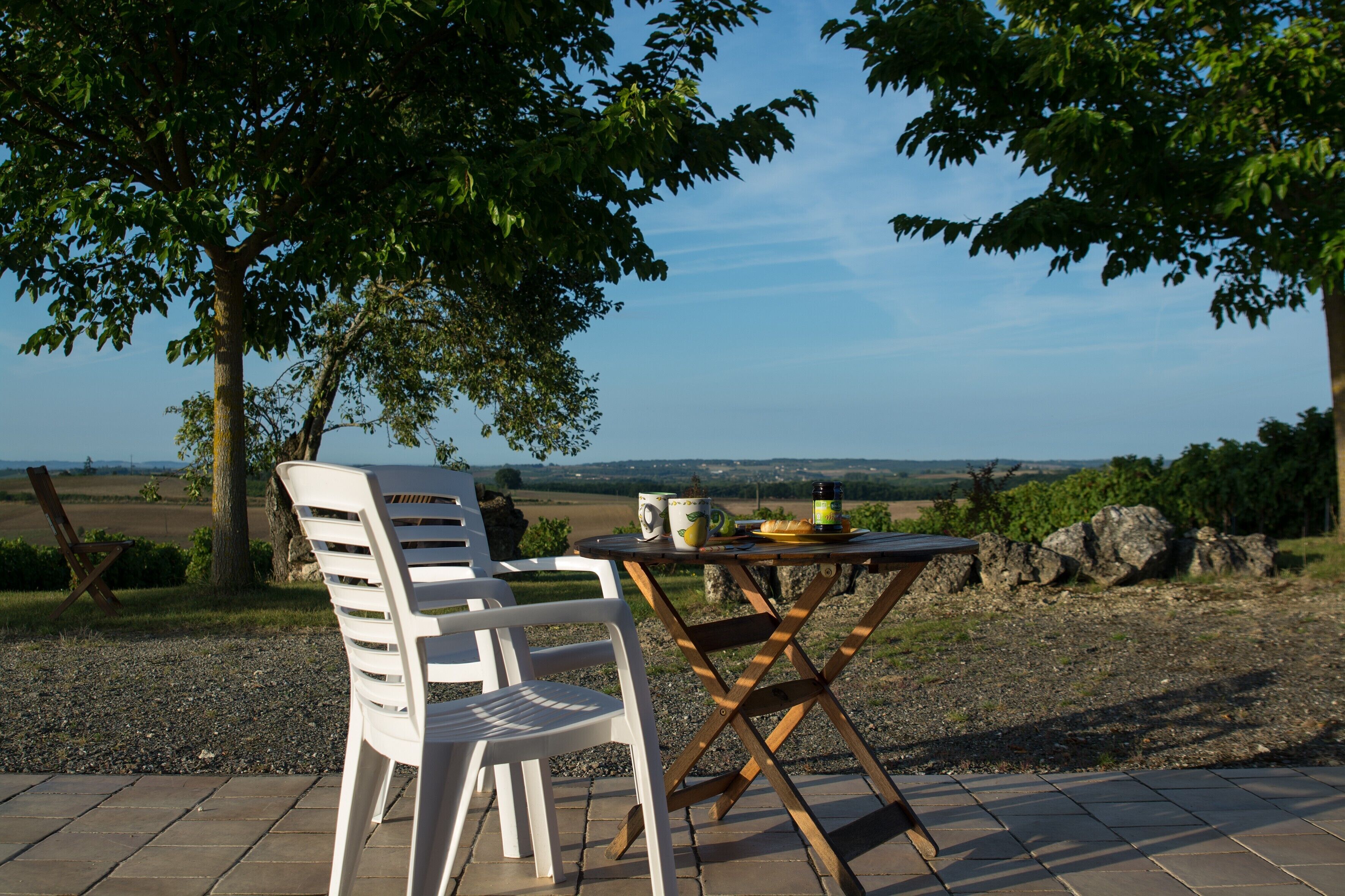 A table and chair set outdoors with a view of the countryside.