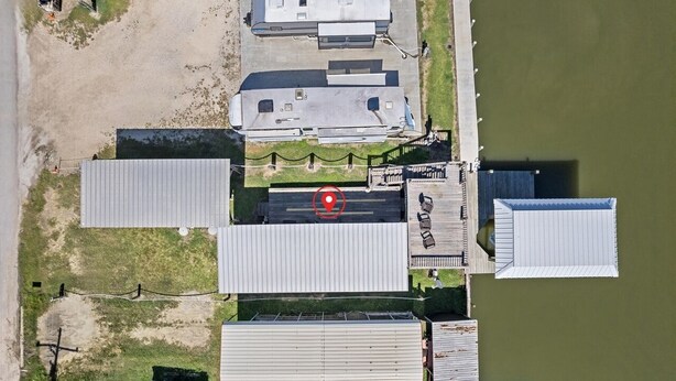 An aerial view of a property with multiple buildings, a dock, and a fenced area. - RV with AC on Bolivar Peninsula (Bolivar Peninsula)