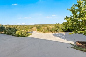 A paved driveway leading to a building with a clear sky. - Guest House 'Suite Simone' with Shared Garden and Air Conditioning (Pranixeddu)