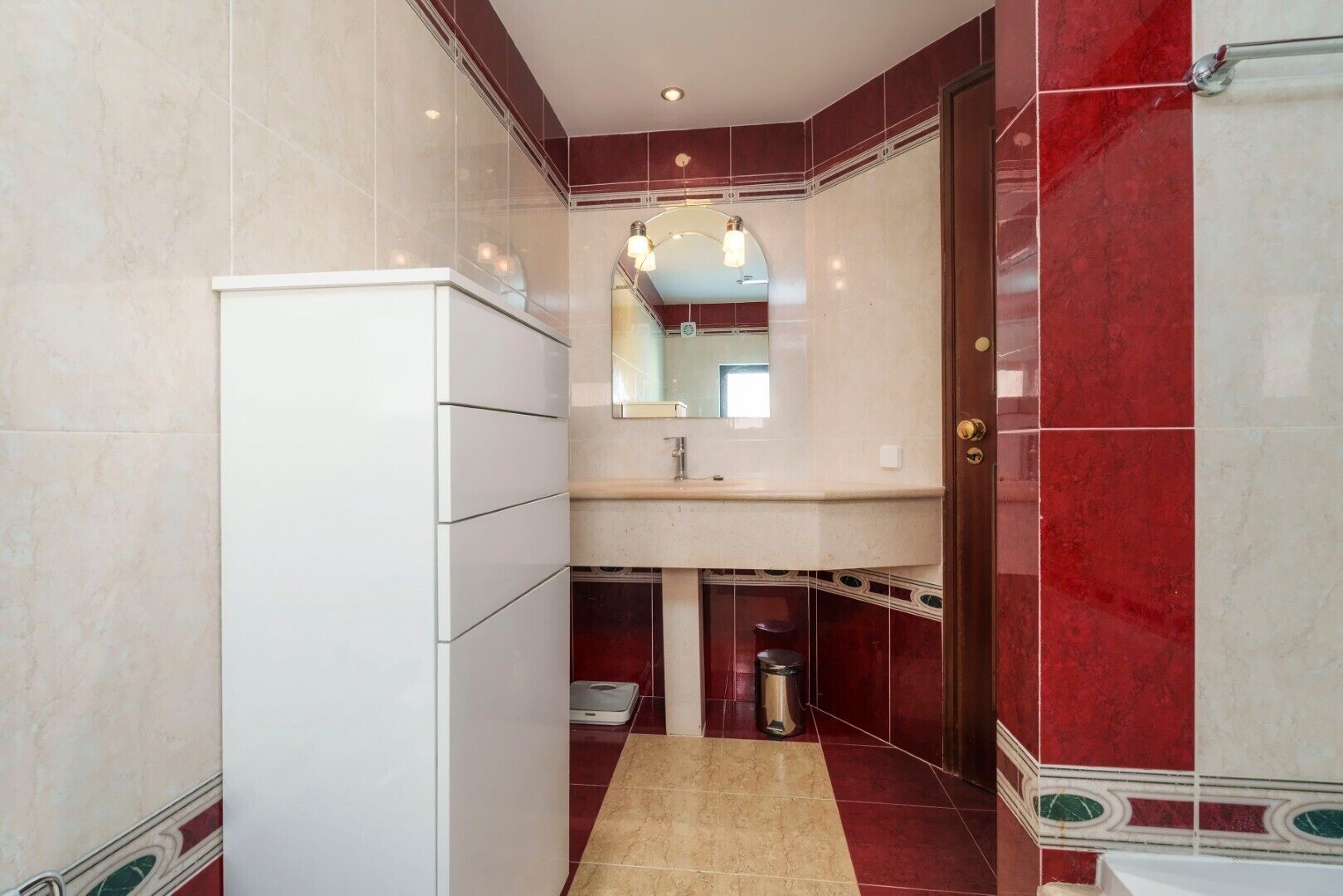 Une petite salle de bain avec un meuble blanc, un lavabo et un miroir.