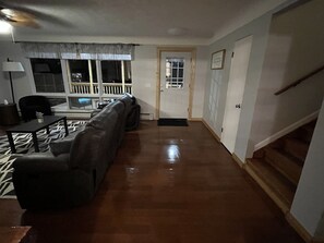 Ein Wohnzimmer mit einer Couch, einem Esstisch und einer Treppe.