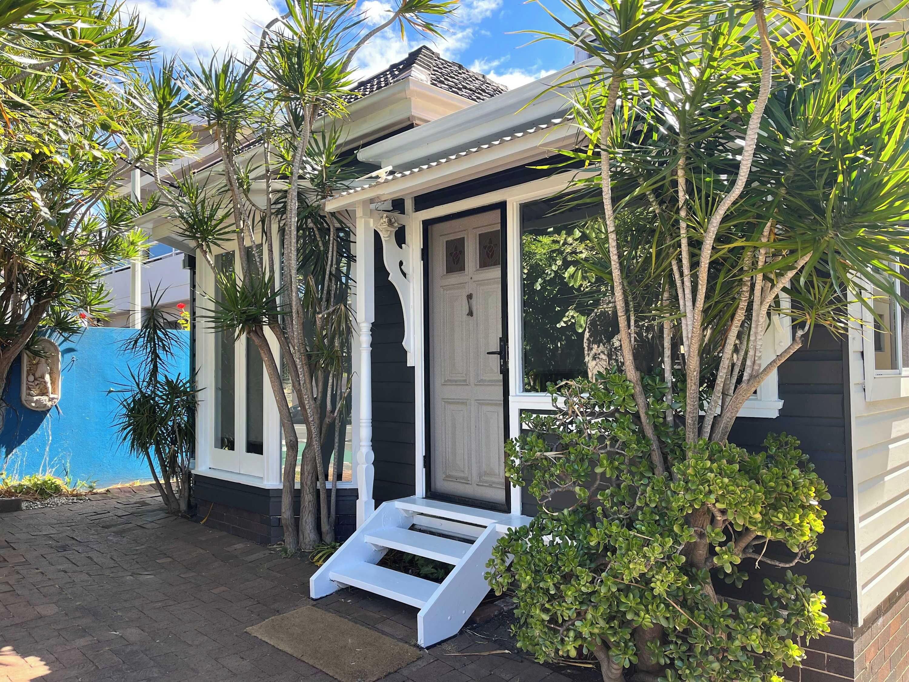 A house with a porch, a door, and a small staircase leading to the entrance.