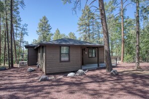 A small cabin with a wooden exterior, a front porch, and a fenced yard. - Modern Cabin in Beautiful Pinetop (Pinetop-Lakeside)