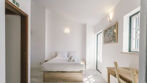 Ein Schlafzimmer mit Bett, Nachttisch und Fenster.