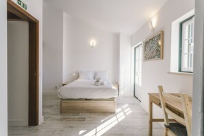 Ein Schlafzimmer mit Bett, Nachttisch und Fenster.